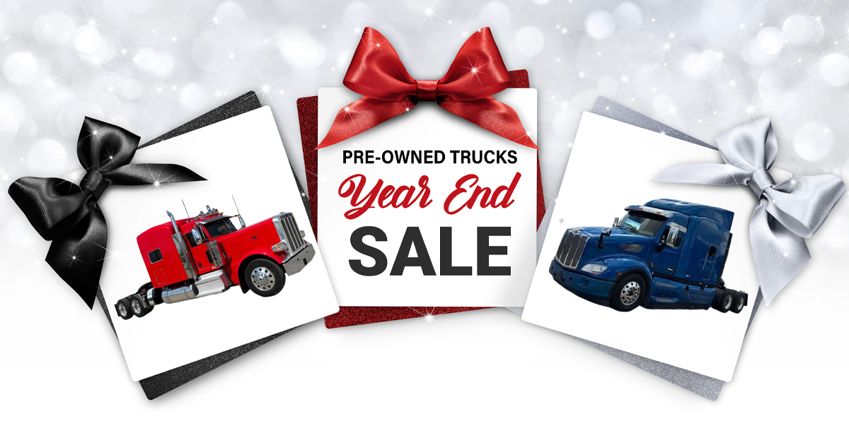 Pre-Owned Trucks Year End Sale - Red & Blue Peterbilt trucks in a box.