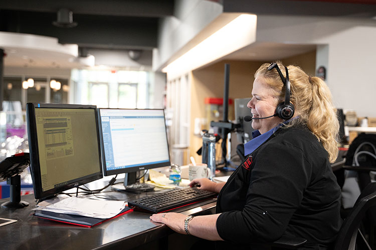 Service Advisor with headset sitting at front desk of dealership