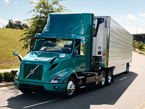 Teal green Volvo VNR on road