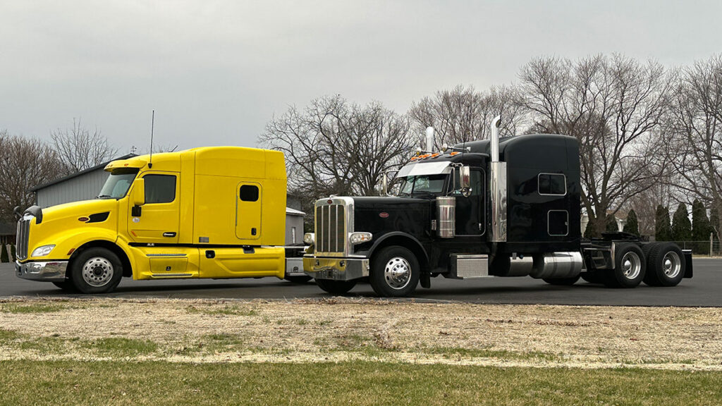 Clean yellow and black Peterbilt semi-trucks ready for the road after spring maintenance.