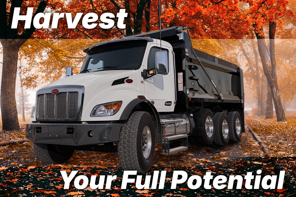 White Peterbilt dump truck surrounded by autumn foliage with text overlay reading Harvest Your Fleet's Full Potential.
