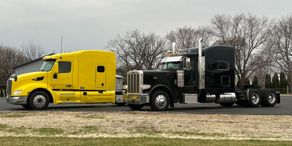 Clean yellow and black Peterbilt semi-trucks ready for the road after spring maintenance.