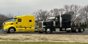 Clean yellow and black Peterbilt semi-trucks ready for the road after spring maintenance.